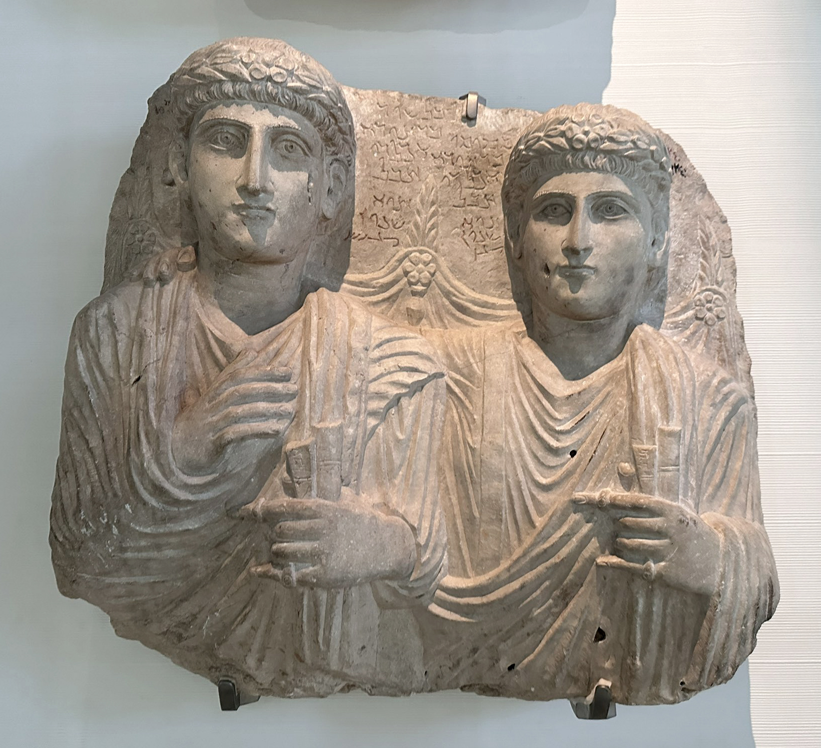 Limestone double funerary bust of Palmyrene brothers Bēlsūr and Moqīmū, sons of Hairē Akkaledi. From Palmyra via al-Qaryatayn, Syria, 2nd century CE. National Museum of Damascus.